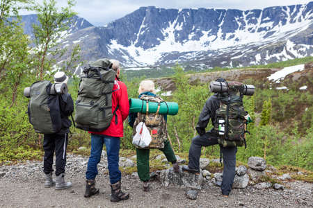 Group of hikers looking at summit range before starting their hiking route, mountaineering in snow mountainsの写真素材