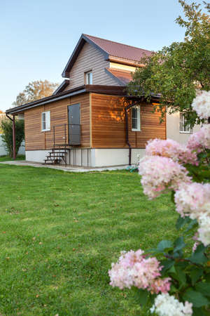 Country house and backyard with flowers and green lawn, nobody, vertical imageの写真素材