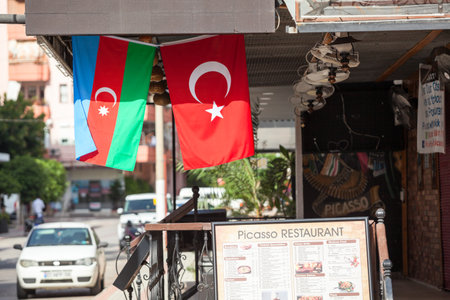 Alanya, Turkey-circa Oct, 2020: The national flag of the Republic of Azerbaijan and the Turkish flag hang in cafe or restaurant on the urban street. Decorated city streets. Alanya, Turkeyのeditorial素材