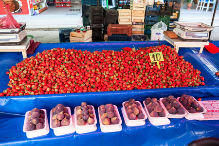 Alanya, Turkey-circa Oct, 2020: Strawberries are on the counter at the vegetable market in city. Seasonal vegetables and fruits are on sale in large bazaarのeditorial素材
