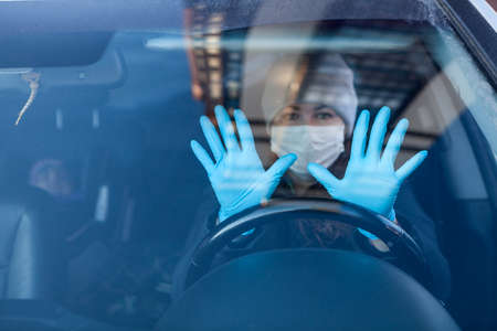 Woman a driver showing her hands in blue rubber gloves, individual preventive measures during the...