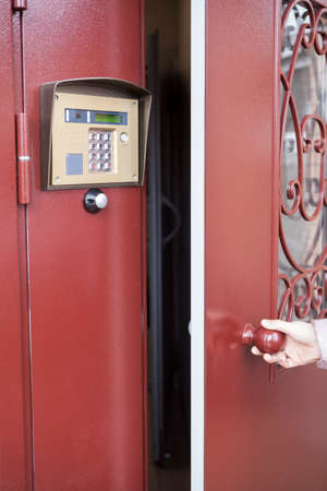 Person opening steel heavy door after intercom communication, home access