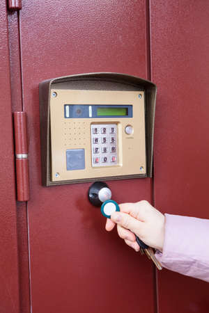 The hand applying RFID key to the intercom. Caucasian person hand close up viewの写真素材