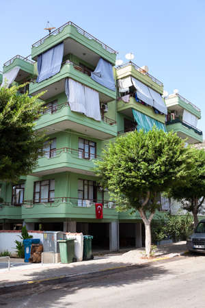 Alanya, Turkey-circa Oct, 2020: Apartment building with balconies covered with linen for sun protection is located in center of city. It is a beach resort city and a district of Antalya Provinceのeditorial素材