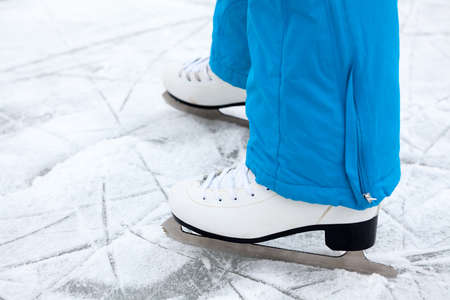 Female legs are in figure skates on a lake ice, close up viewの写真素材