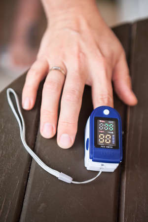 Female using oximeter for monitoring peripheral oxygen saturation, close-up viewの写真素材