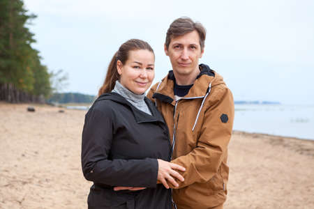 Middle age loving couple portrait standing together on coastline of northers seaの写真素材