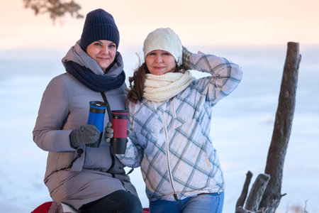 Two girlfriends walking together at Febriary cold winter dayの写真素材