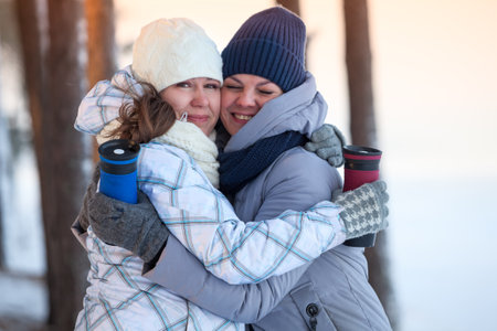 Two women hugging together, outdoorの写真素材