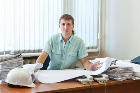Architect or designer qualified in structural design working on the detailed project report in an office, looking at cameraの写真素材