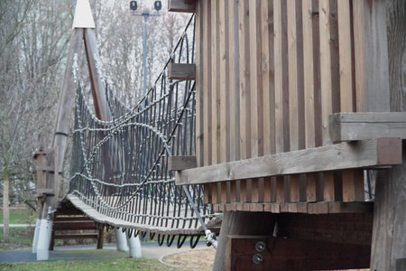 view from below wooden suspension bridge with thick ropes and planks dramatic perspective adventure travel nature outdoor hiking structureの写真素材