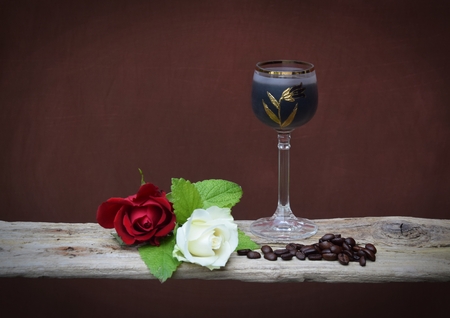 White and red roses with a liqueur glass on a wooden board