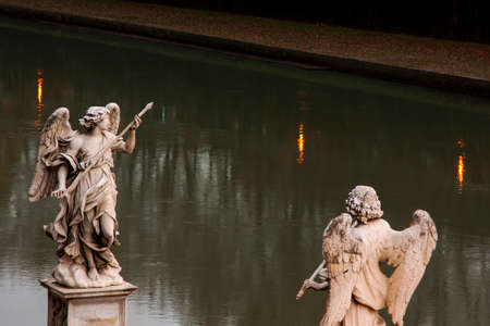 Two statues of angels of bridge of angels against the background of the river in Rome.の写真素材