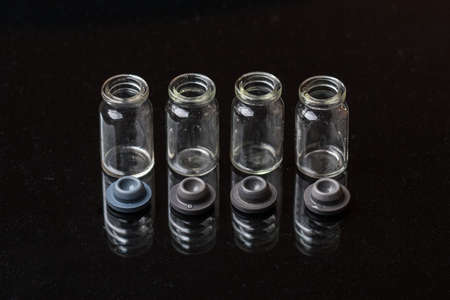Medical empty glass flasks on black background