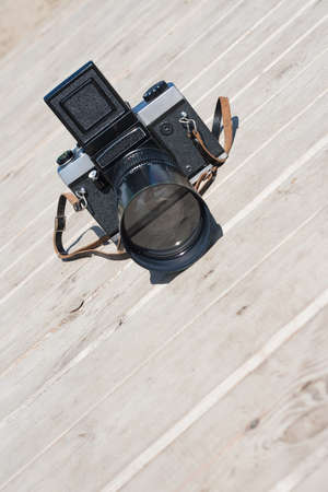 Old photo camera on wooden surface