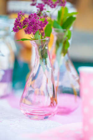 A small bouquet of flowers in a glass vase in pink tonesの写真素材