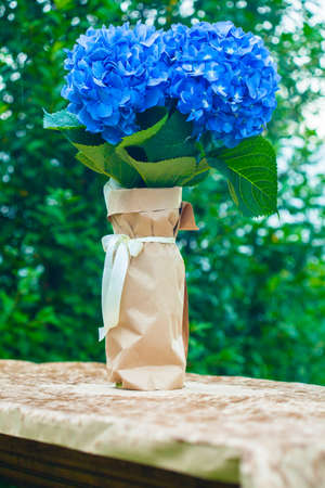 Bouquet of hydrangeas on the table in the garden on a rainy, cloudy day