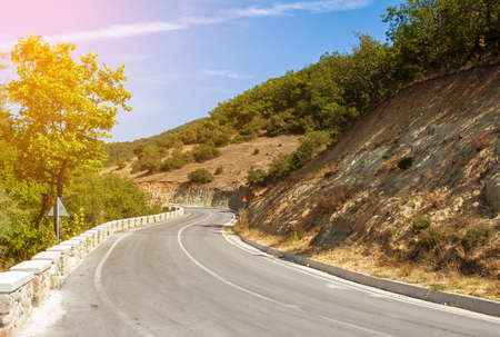 Winding paved mountain road in the sunlight