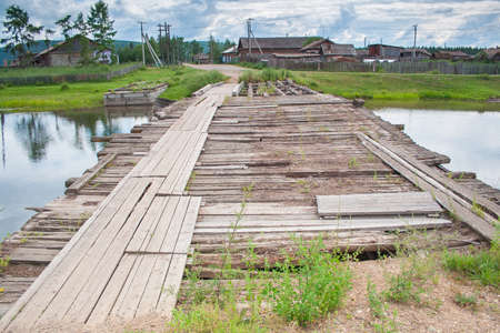 Old ruined wooden bridge across the river. Rural broken crossing of the Creek. Rural landscapeの写真素材