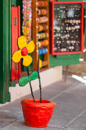 Souvenirs Of Spain. Yellow colorful flower ceramic red pot. Garden figures with their handsの写真素材