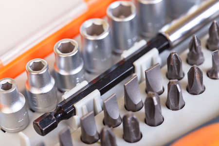 Set heads under the nut. Metal bits and flat-head screwdriver. Nozzles and adapters for...