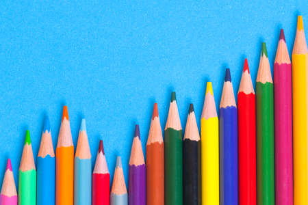 Wooden color pencils on a blue background. Prospect. The leads of colored pencils. Colored pencils closeup in the form of a ladder.の写真素材