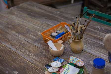 Paint brushes in a vase. Tools and accessories for manual work. Blurred paints, brushes in a jar....
