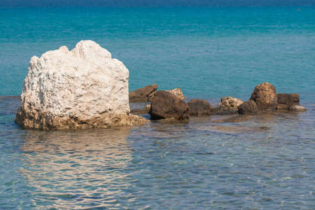 The rocky entrance to the sea. The coastal area of the Mediterranean. A large white rock sticking out from the blue waters of the sea.の写真素材