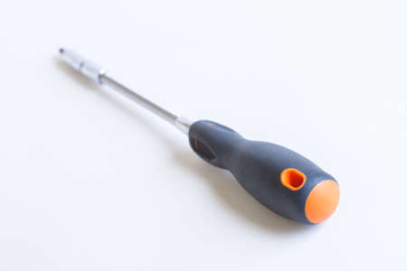 Screwdriver on a light background. Grey plastic handle with orange accents.の写真素材