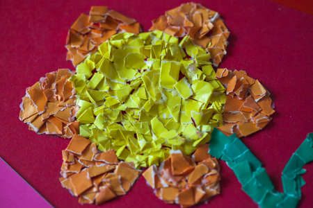Handmade crafts from colored paper. Flower of small particles of paper