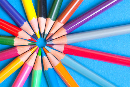 Wooden color pencils on a blue background. The tips of the pencils look in the center of the circle. The wooden texture of the pencils.の写真素材