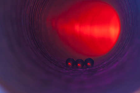 Transparent small beads on the surface inside the cylinder illuminated by bright lightの写真素材