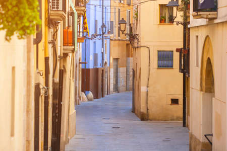 Deserted street of old European town on a clear Sunny day. The bright walls of the city of Tarragona in Spain.の写真素材
