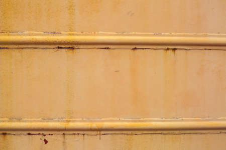 Paint smudges on the surface. Rusty yellow background. Painted metal surface. The surface of the train as the background element. Metal painted in yellow.の写真素材