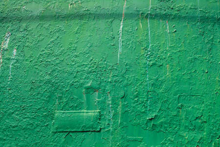 The label on the metal surface. Paint smudges on the surface. Old green background. Painted metal surface.The surface of the train as a background element.Metal painted in red. Peeling old green paintの写真素材