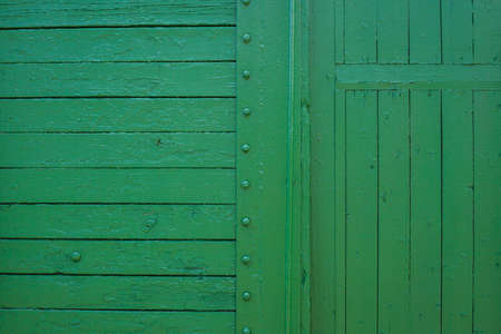 Wooden boards painted in green. Old green background. Painted wood surface. The surface of the train as a background element. The surface of the wooden green train car. The line of boards
の写真素材