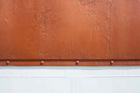 White stripe on a red background. Paint smudges on the surface. Red rusty background. Painted metal surface. The surface of the train as a background element. Metal painted in white and red.の写真素材