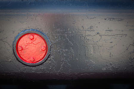Black background. Painted metal surface. A red object on a black background. Metal painted black. Red cover on black case.の写真素材