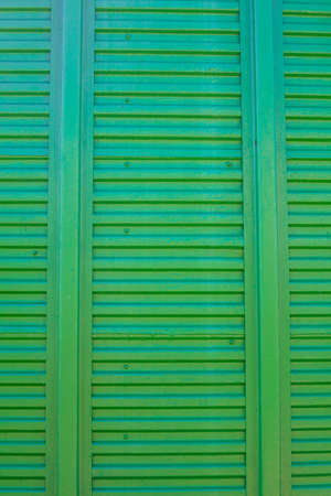 Old green background. Metal door wooden freight car. The texture of the train car. Stamped metal surface is dark green
の写真素材