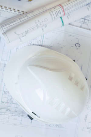Accessories Builder. White protective helmet is on the pictures. Coil designs lie on documentsの写真素材
