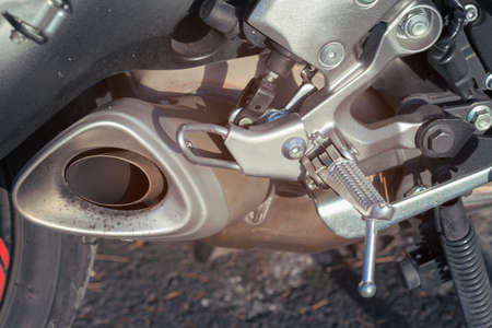 The element of the exhaust system of a motorcycle. Folding footrest for rear passenger of the motorcycle. Part of the mechanism of the bike close-upの写真素材
