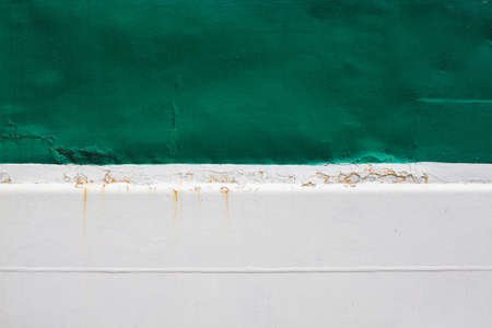 Green stripe on a white background. Paint smudges on the surface. White rusty background. Painted metal surface. Metal painted in white and green.の写真素材