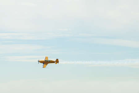 Yellow turboprop sport plane flies under the radar. The plane leaves behind in the sky a trace of...