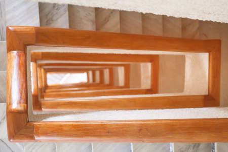 Stairs spiral curls deep down. The tunnel from the stairwell. Perspective of stair railings in the...