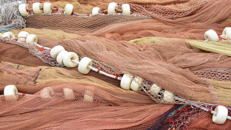 Fishing nets of brown shades with white floats