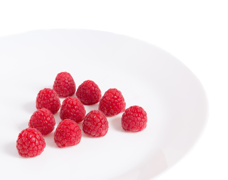 Raspberry berries on a plate on a white background