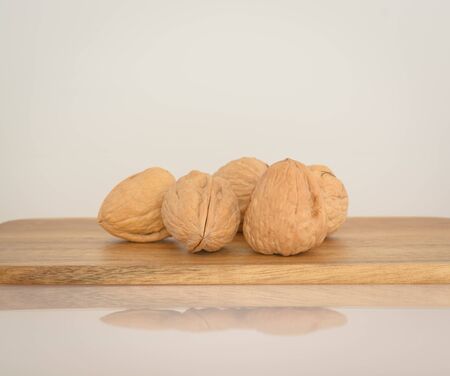 Walnuts on a wooden board on a light gray background