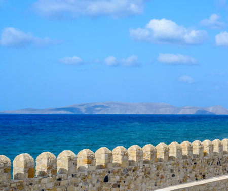 View of the jagged top of the fortress wall, the sea and the island in the distanceの写真素材