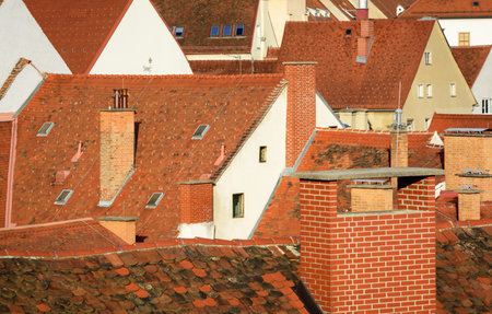 View of urban red tiled roofs with brick chimneys in a horizontal formatの写真素材