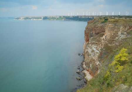 View of the Black Sea, coastline with cliff and wind turbines in the distance on a sunny day in Bulgariaの写真素材